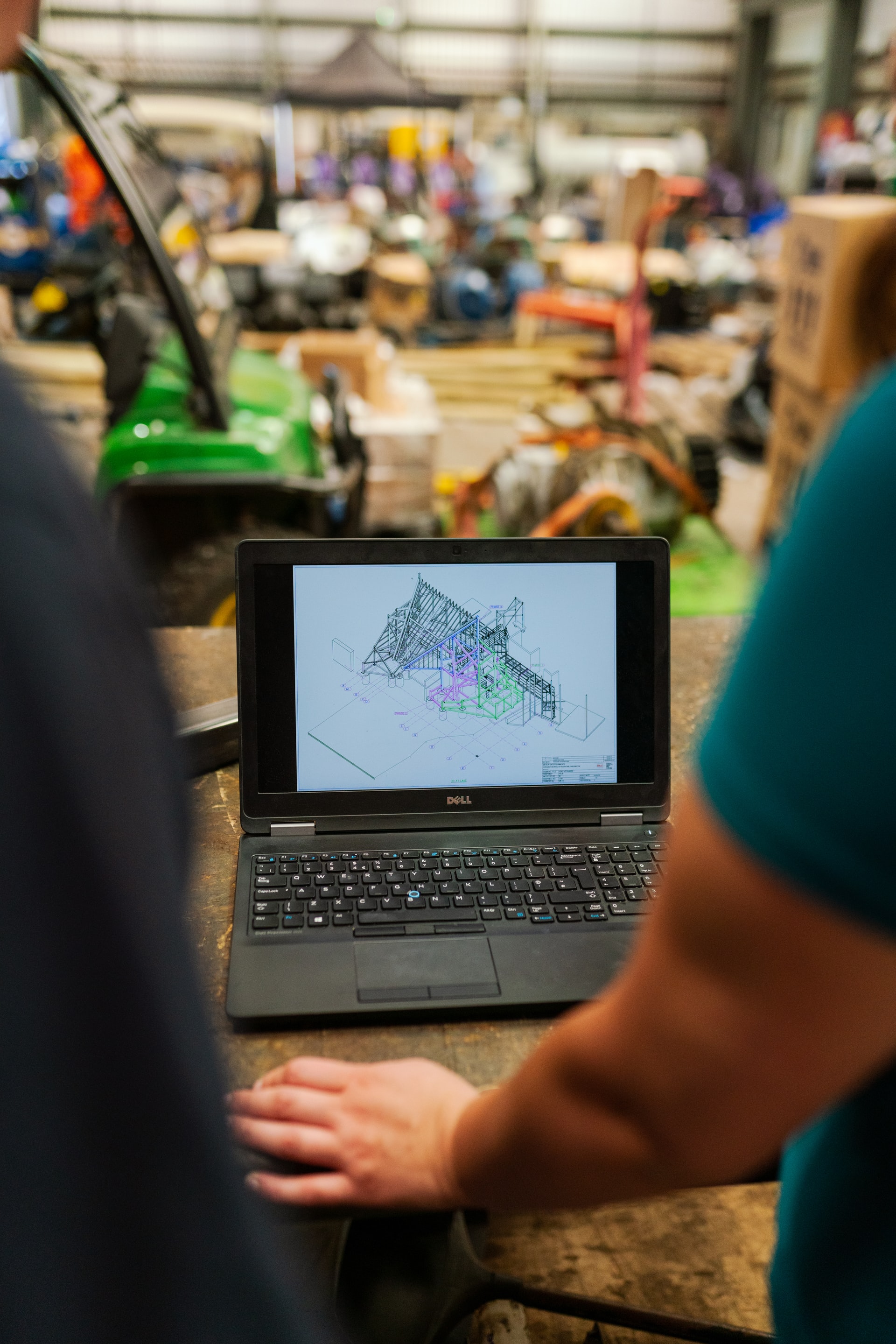 People looking at a computer with robotics in the background