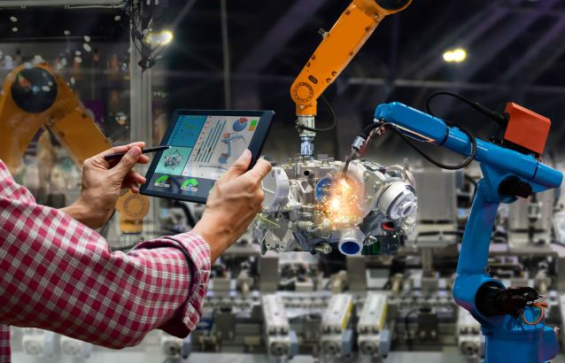 technician-holding control screen in front of mechanical arm 