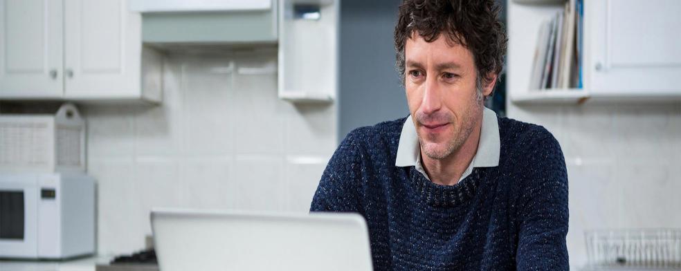 Image of a man working on a laptop