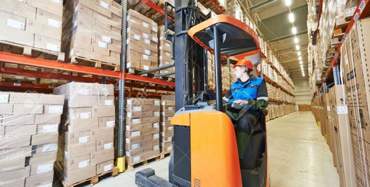 warehouse worker moves pallets with forklift