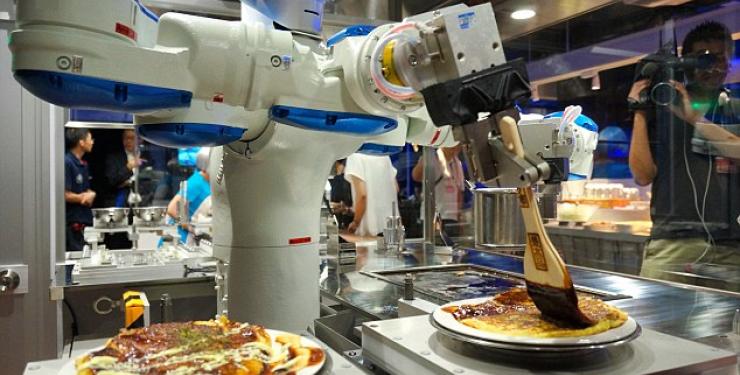 Kitchen robot making pizza